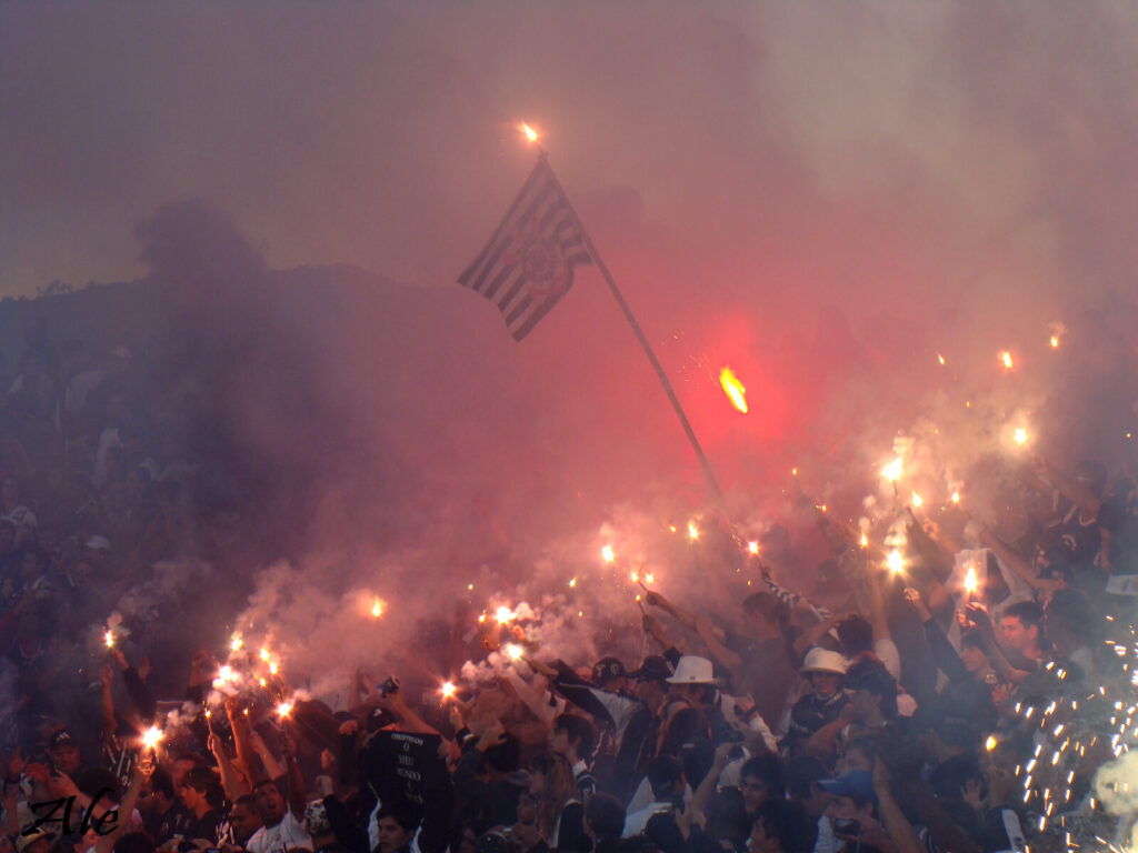 Torcida do Corinthians (Fiel) comemorando com bandeiras do clube nas arquibancadas