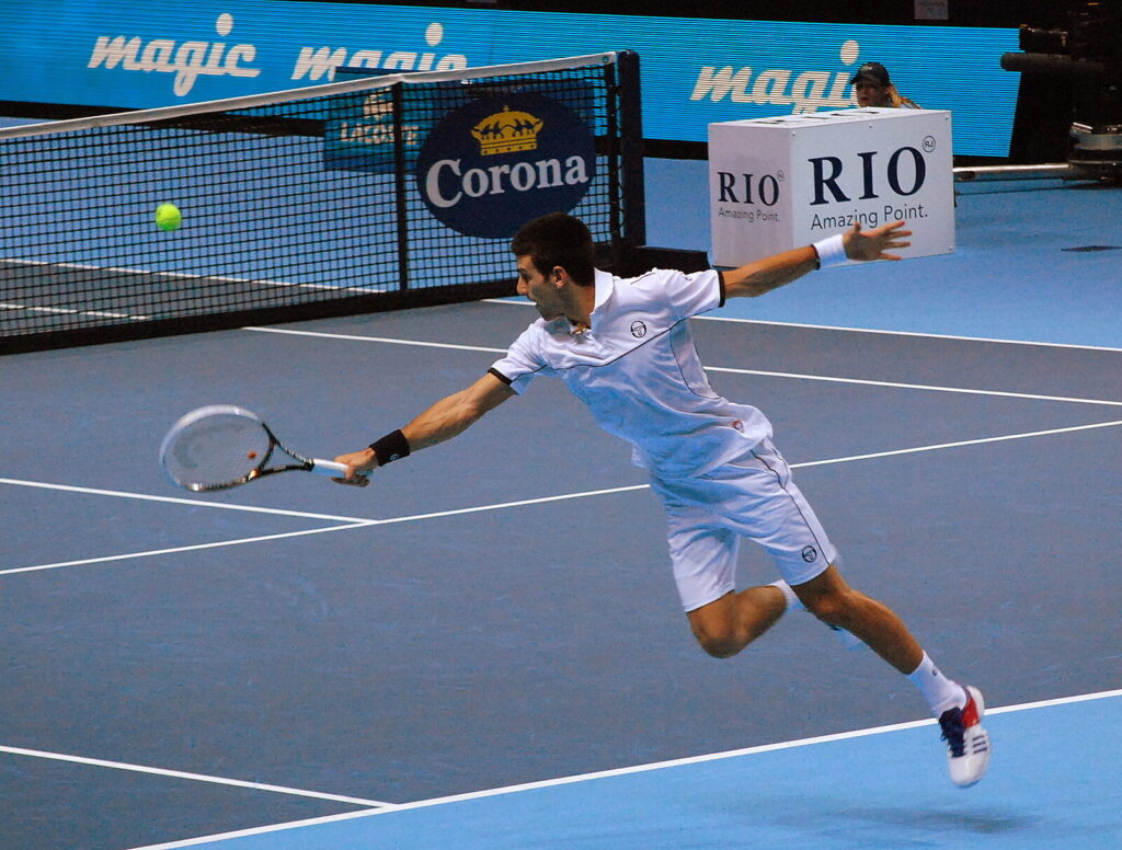 Novak Djokovic se estica para rebater a bola durante partida do ATP Finals