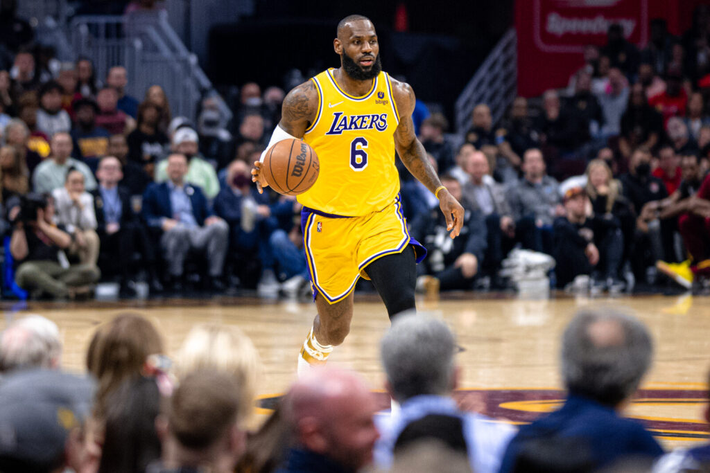 LeBron James, com a camisa dos Lakers, driblando durante jogo contra o Cleveland Cavaliers