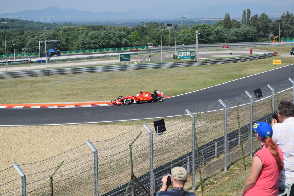 Carro de F1 da Ferrari pilotado por Sebastian Vettel em curva do Hungaroring durante treino livre