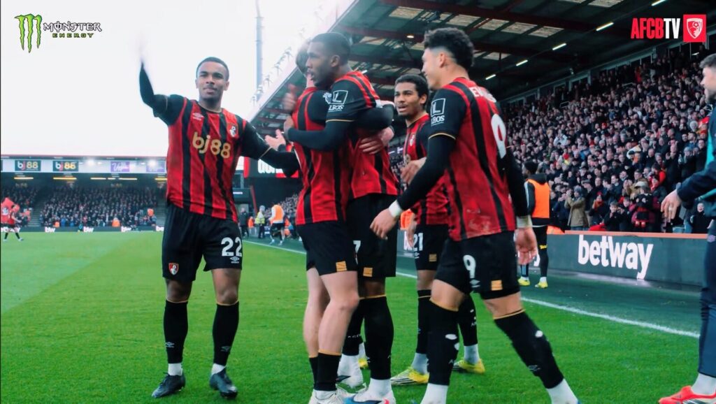 Jogadores do AFC Bournemouth comemoram gol abraçados no gramado, com arquibancada cheia ao fundo (Foto de arquivo: jogadores do Bournemouth comemoram gol contra o Aston Villa na Premier League 2025/26, não contra o Manchester City.)