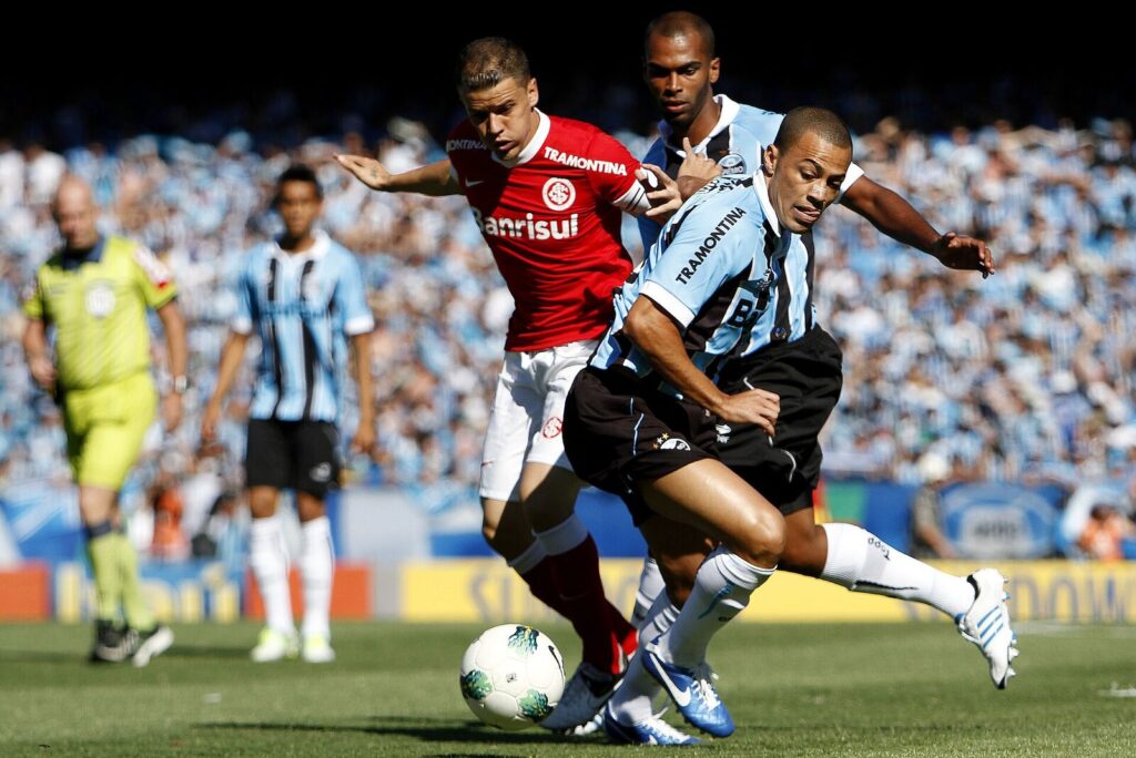 Jogadores de Grêmio e Internacional disputam a bola durante um Gre-Nal no Estádio Olímpico Monumental (Foto de arquivo: lance de um Gre-Nal disputado em 2012, no Estádio Olímpico Monumental.)