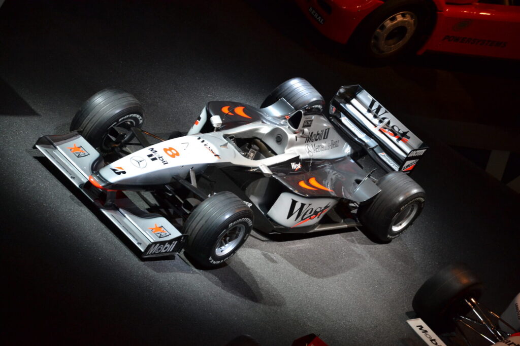 Carro de Fórmula 1 da McLaren em exposição, com as asas dianteira e traseira visíveis (Imagem de arquivo: carro de F1 histórico em exposição, usado apenas para ilustrar elementos aerodinâmicos (asas) do esporte.)