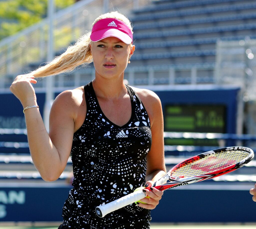 Kristina Mladenovic no US Open de 2014, segurando raquete à beira da quadra (Foto de arquivo: Kristina Mladenovic no US Open de 2014, não relacionada à edição atual do torneio.)