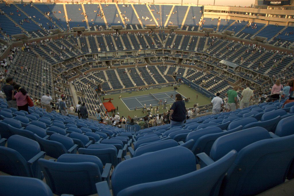 Vista interna do Arthur Ashe Stadium, principal quadra do US Open, com arquibancadas cheias durante uma partida (Foto de arquivo do Arthur Ashe Stadium, sede do US Open (imagem não é do torneio de 2026).)