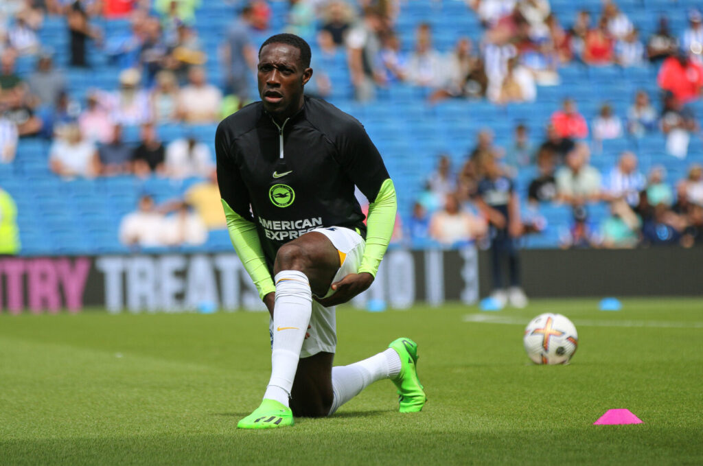 Danny Welbeck se alonga em campo durante aquecimento com o uniforme do Brighton & Hove Albion