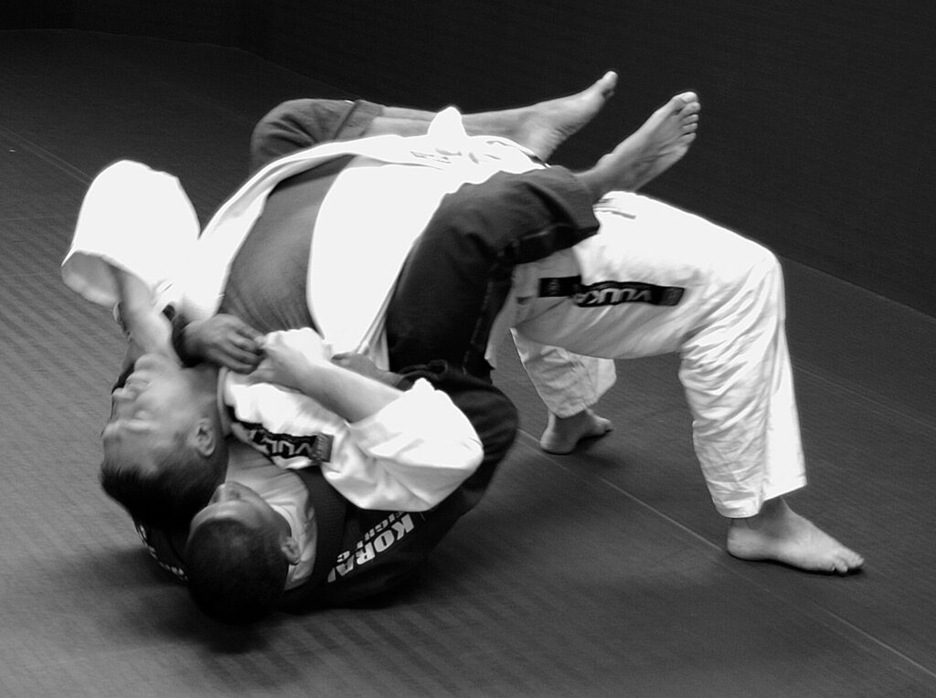 Praticantes de jiu-jitsu em treino, um escapando da pegada pelas costas no tatame (Foto ilustrativa de treino de jiu-jitsu (Springfield, EUA, 2010).)