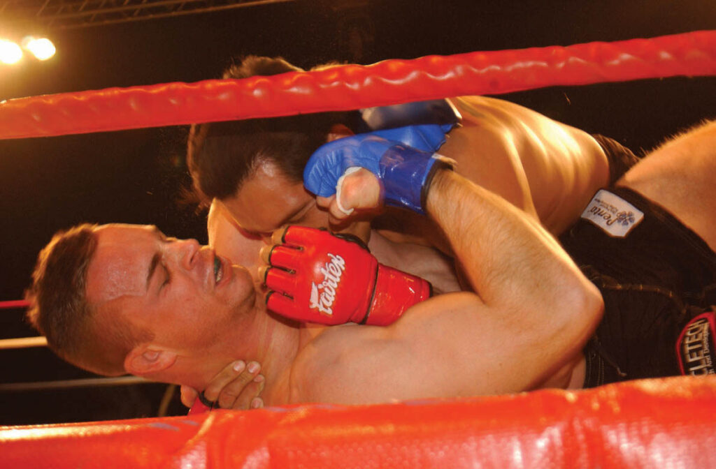 Lutador de MMA aplicando golpes no solo durante combate no evento Total Combat, no Arizona (Foto de arquivo: luta de MMA amadora no Arizona (2005), usada apenas para ilustrar o esporte.)